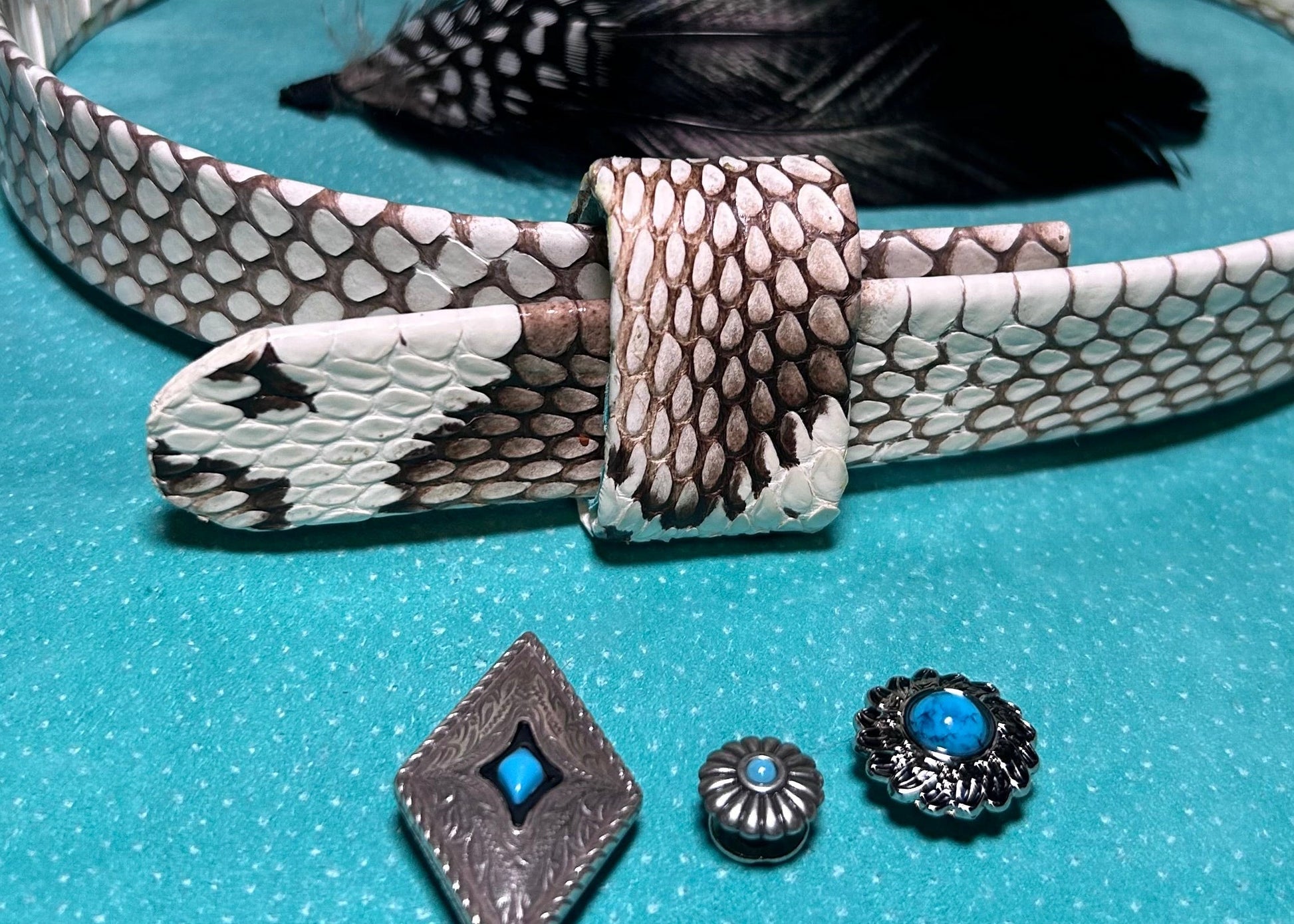 Silver belt with snake skin pattern and decorative elements on a blue background